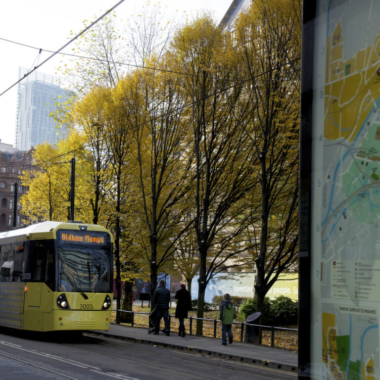 Manchester Tram next to map of Manchester