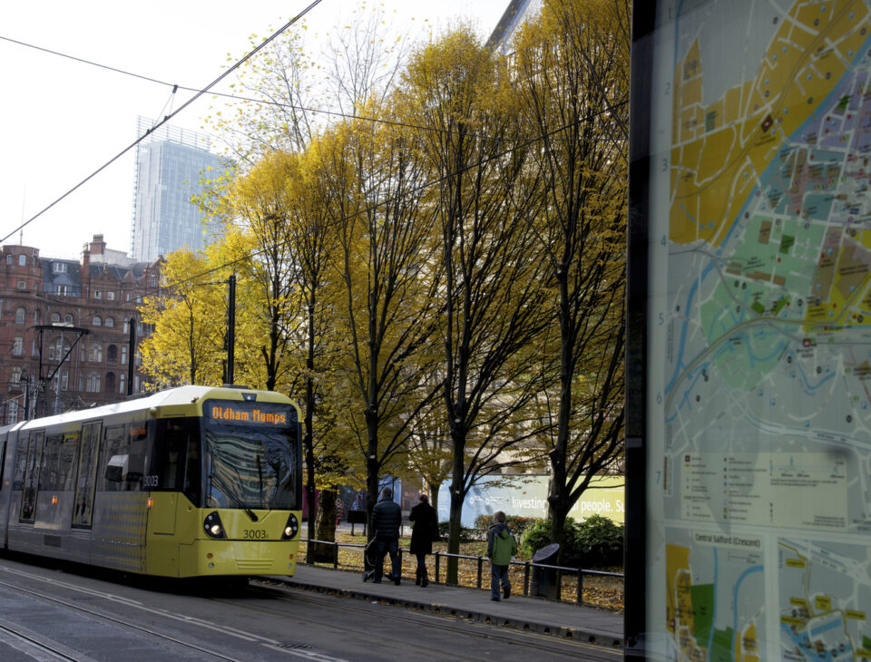 Manchester Tram next to map of Manchester