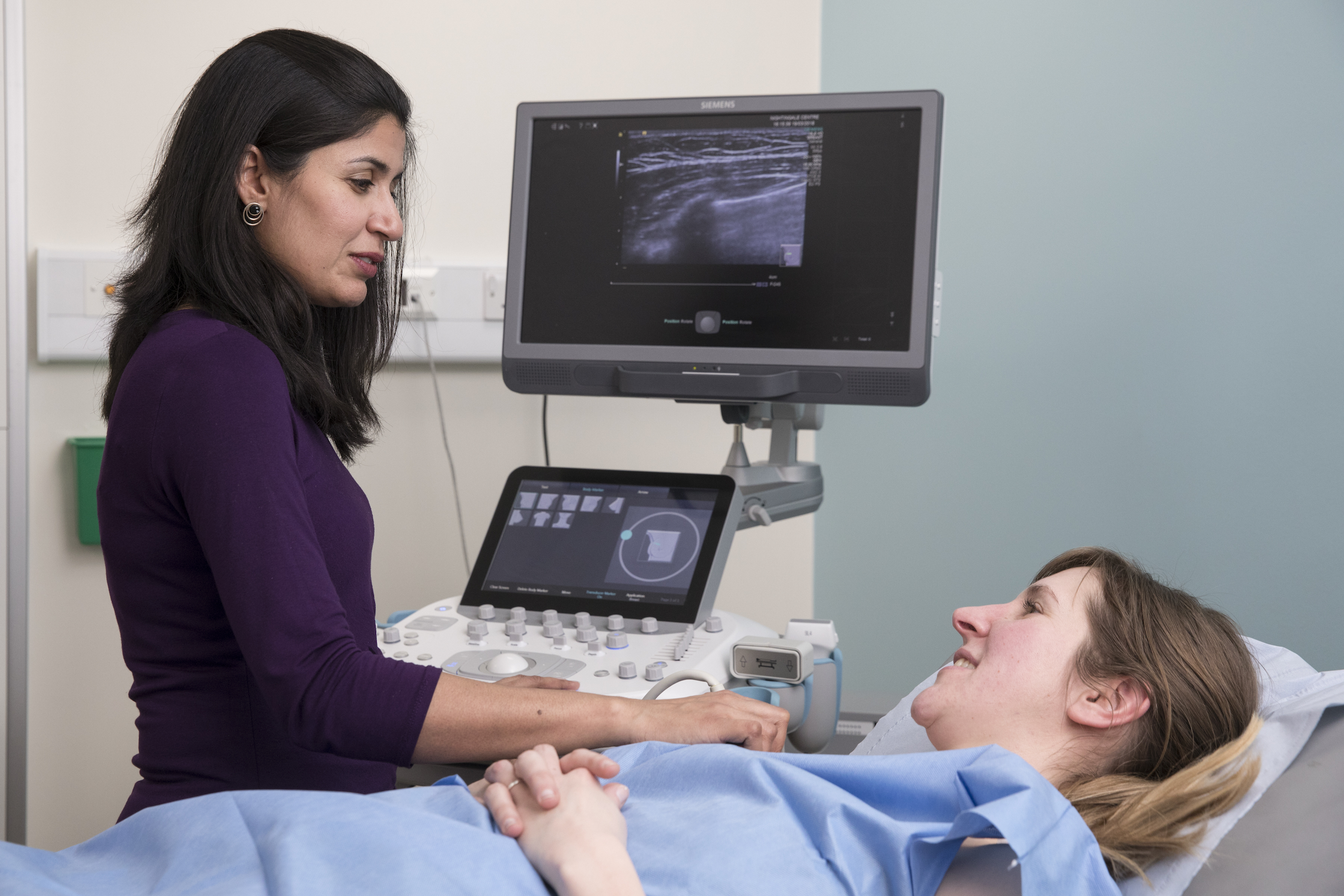 A doctor carrying out a scan on a female patient