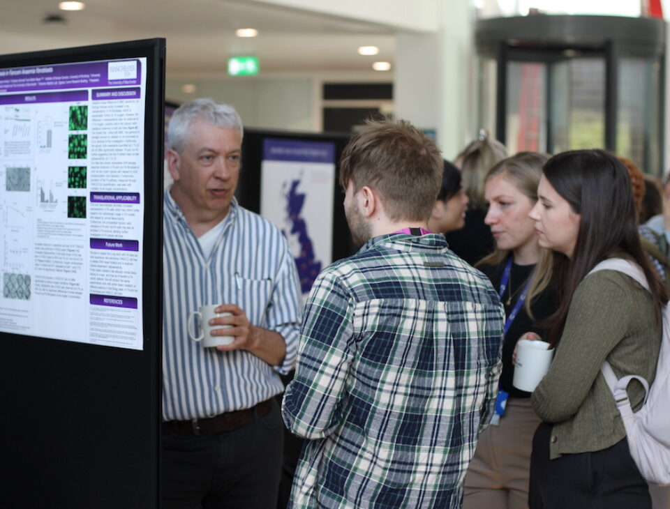 Academics and PhD students at the PGR showcase in front of academic posters within the OCRB