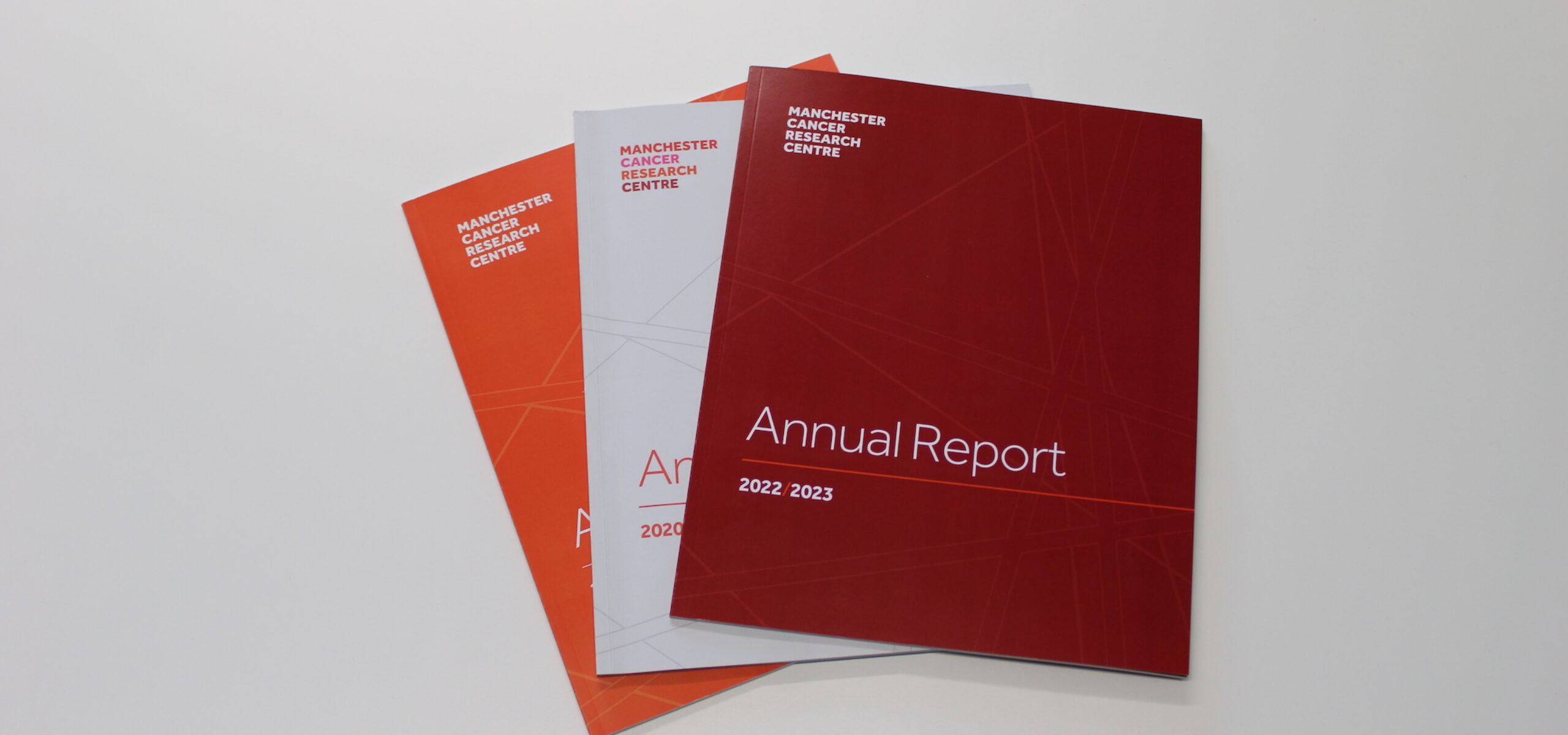 Three issues of the MCRC Annual Report stacked on top of each other with 2022/2023 issue on top