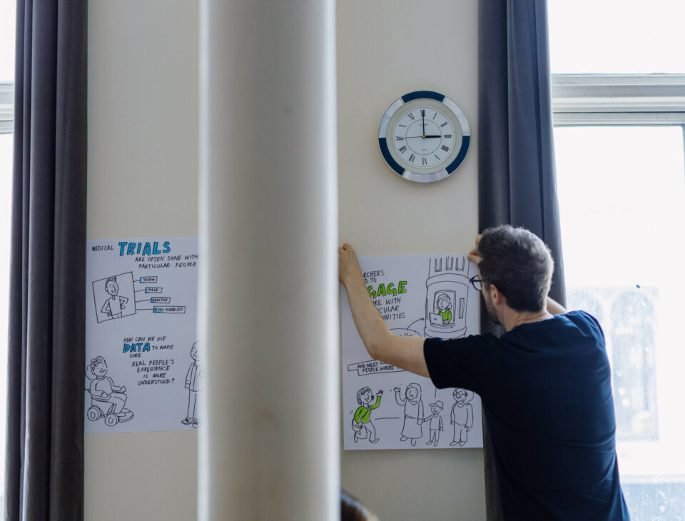 Man sticking visual minutes posters to the wall.