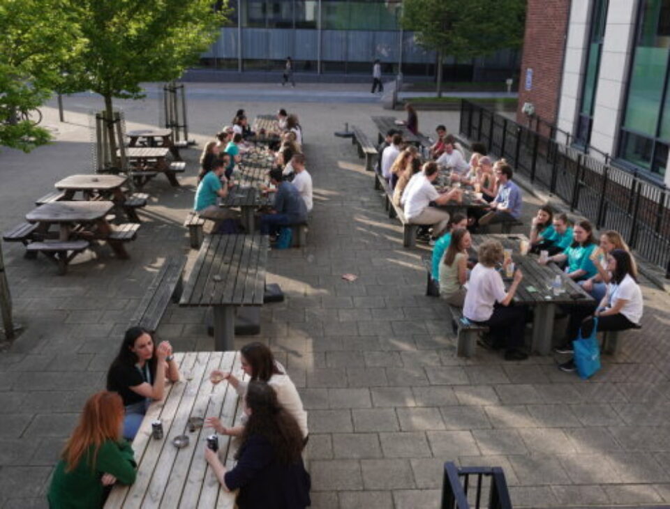 PhD students enjoying the sun outside of Manchester Students' Union