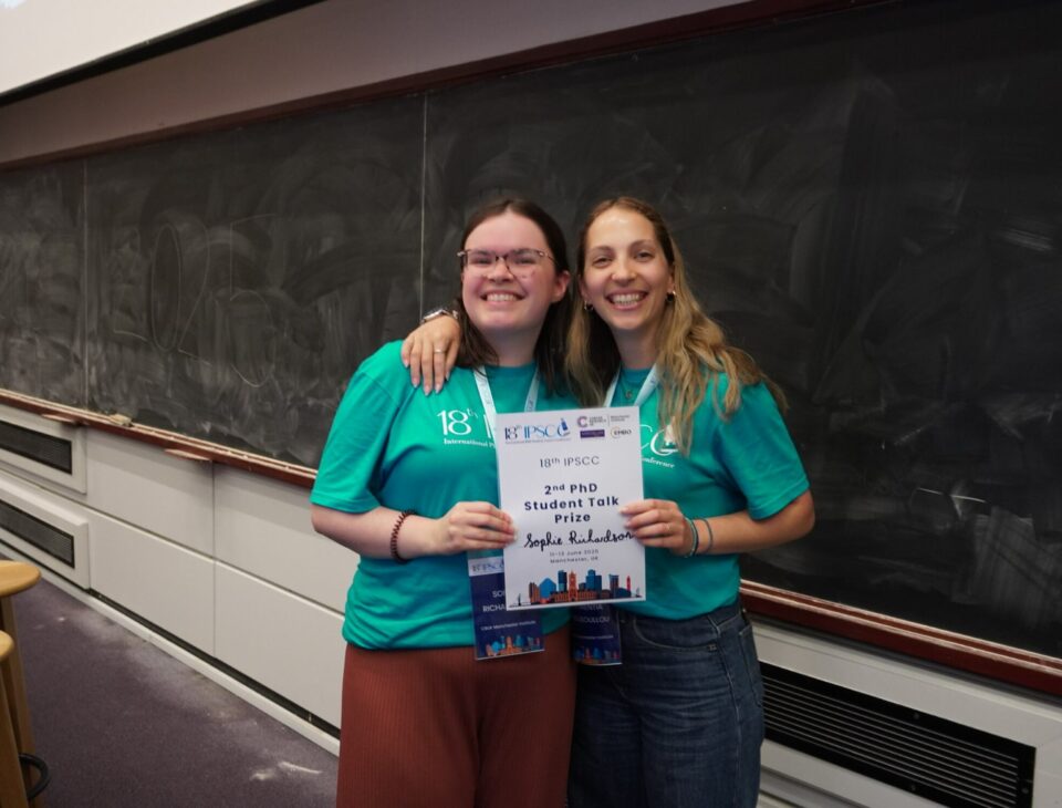 Sophie Richardson (left) and Florentia Mousoullou (right) both holding a certificate in a lecture theatre